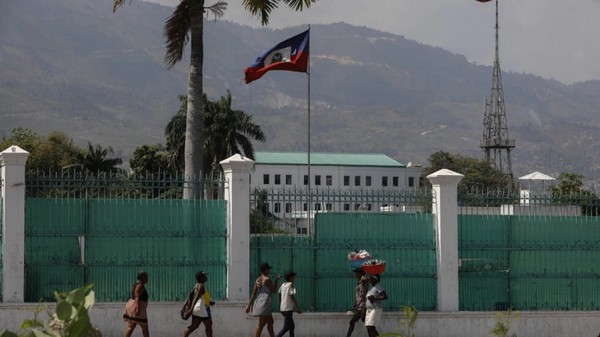 Photo de Hatiens passant devant le palais national  Port-au-Prince en mars 2024.
