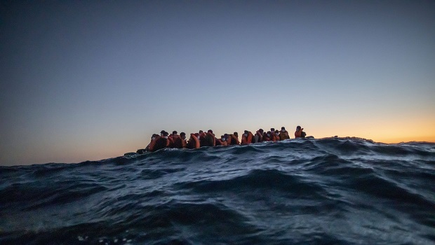 Photo de migrants en situation prcaire au sommet de vague.
