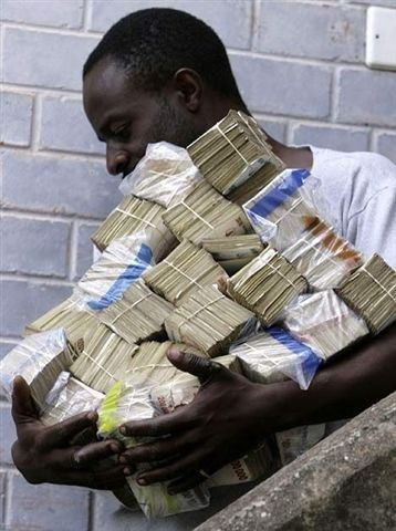 photo d'un homme transportant un tas de liasses de billets au Zimbabwe