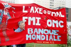 photo d'une banderole de manifestants mentionnant Axe du Mal : FMI, OMC, Banque Mondiale.