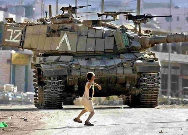 Photo de gamin palestinien envoyant pierre sur char israélien.