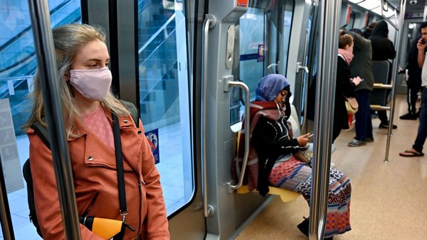 Photo de jeune femme portant masque dans métro.