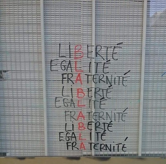 Photo d'un store grillagé portant graffiti de la devise -Liberté, Egalité, Fraternité-.