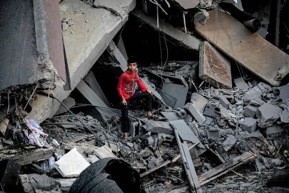 Photo de gamin debout dans les ruines d'un immeuble  Gaza City, le 26 octobre 2023.