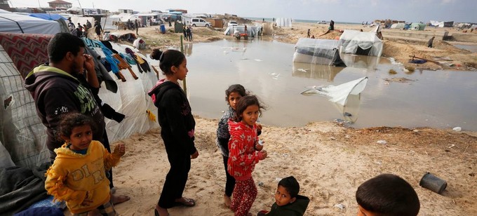 Photo de campement de fortune inond avec groupe d'enfants  Gaza.