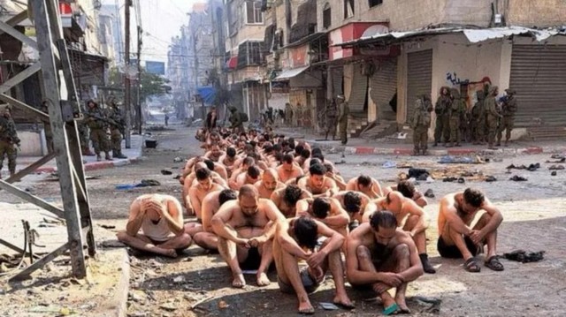 Photo de prisonniers dnuds dans une rue  Gaza sous surveillance de troupes israliennes.