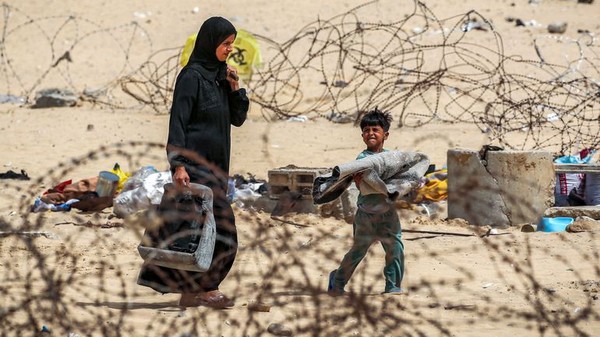 Photo de femme et enfant dans Gaza  travers barbels en 2024.