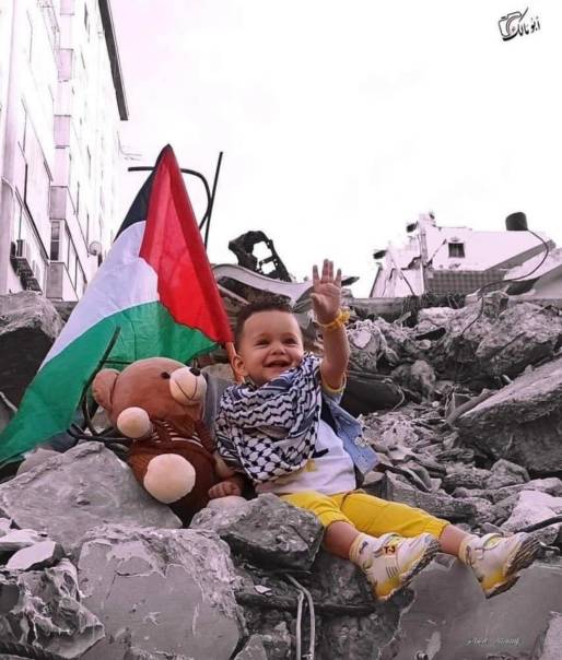 Photo de bébé palestinien faisant un salut dans les ruines.