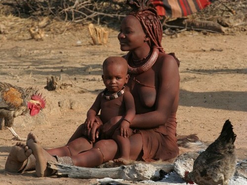 Photo de jeune femme africaine, Namibie, assise, tenant enfant sur ses jambes.