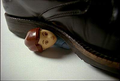 image d'une botte pesant sur une figurine dont dépasse la tête.