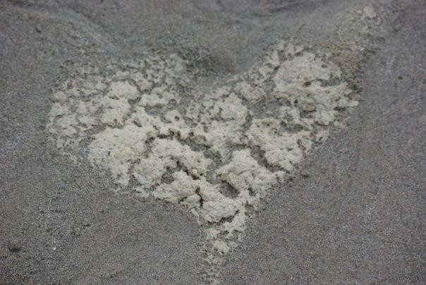 Photo de coeur d'écume sur sable en gris et blanc.